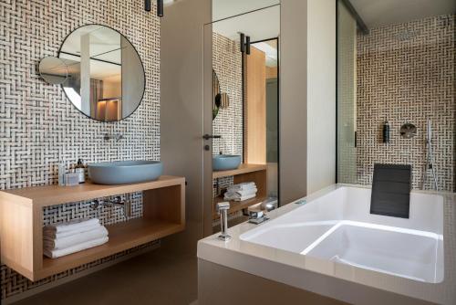 a bathroom with a large tub and a mirror at Hotel San Marco in Cattolica