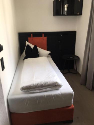 a bed with white sheets and pillows in a room at Boutique Hotel Edelweiss in Sankt Anton am Arlberg