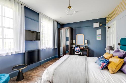 a bedroom with blue walls and a large bed at St Martins Lodge in Leicester