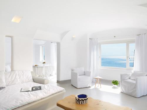 sala de estar blanca con sofá y 2 sillas en Mykonos Blu, Grecotel Boutique Resort, en Psarou