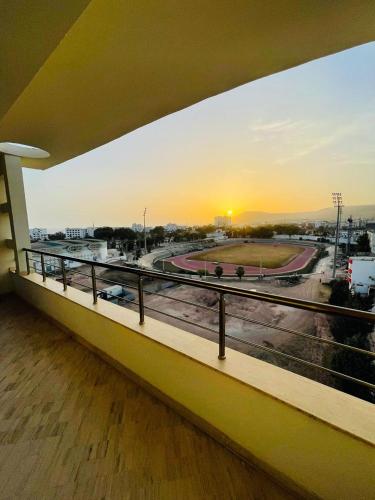 a balcony with a view of a highway at sunset at Very nice apartment near the city center & beach in Agadir