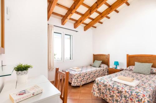 a room with two beds and a table at Villa Santi III by Villa Plus in Cala'n Porter