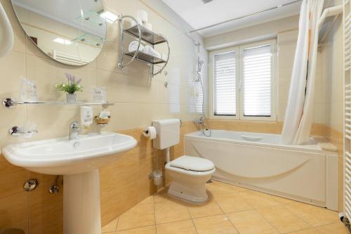 a bathroom with a sink and a tub and a toilet at Villa Riva in Makarska