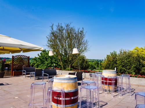 a patio with tables and chairs and barrels at Active Hotel Paradiso in Peschiera del Garda