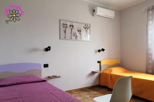 2 camas en una habitación con morado y naranja en VILLA MARGHERITA, en Rogiano Gravina
