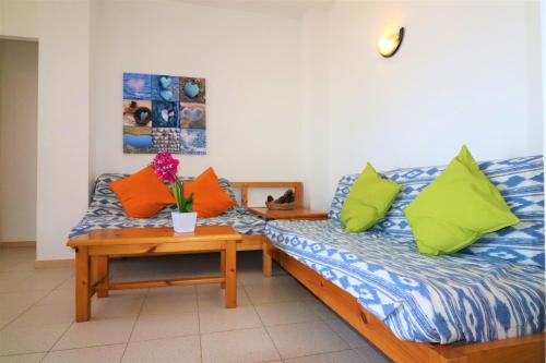 een kamer met een bed met kleurrijke kussens en een tafel bij Mediterraneo 2 3 6 Roses - Immo Barneda in Roses