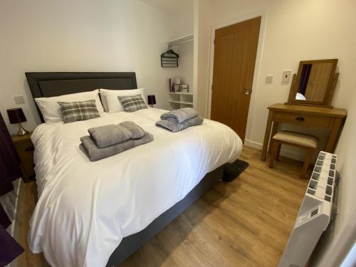 sypialnia z dużym białym łóżkiem z 2 poduszkami w obiekcie White Cottage - Cosy Holiday Cottage in Drymen, Loch Lomond & Trossachs w mieście Drymen