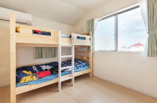 une chambre avec deux lits superposés et une fenêtre dans l'établissement ゆうゆう布佐駅新築戸建Free Wifi, à Abiko