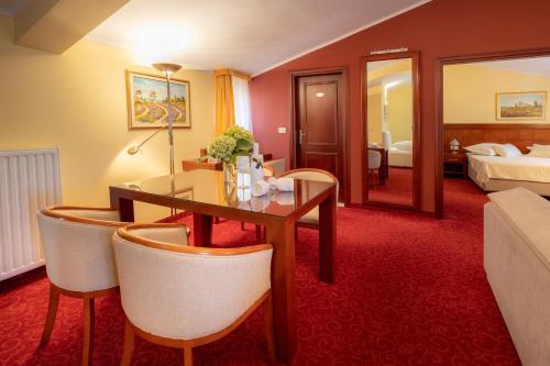 um quarto de hotel com uma mesa e cadeiras e uma cama em Villa Riva em Makarska