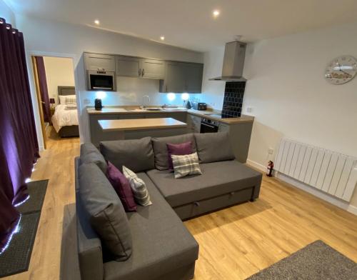 a living room with a couch and a kitchen at White Cottage - Cosy Holiday Cottage in Drymen, Loch Lomond & Trossachs in Drymen