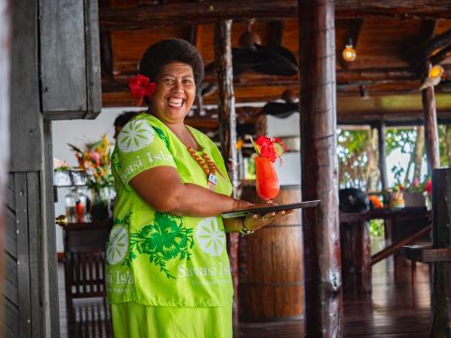 a woman holding a red bird on a clipboard at Savasi Island Resort in Savusavu