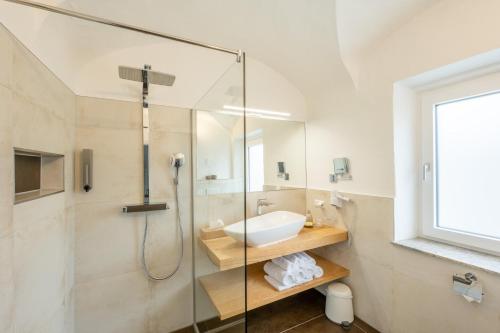 a bathroom with a glass shower and a sink at Smarthotel Völkermarkt in Völkermarkt