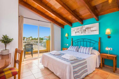 Un dormitorio con una cama y un balcón. en Villa Benjamin by Villa Plus, en Sa Caleta