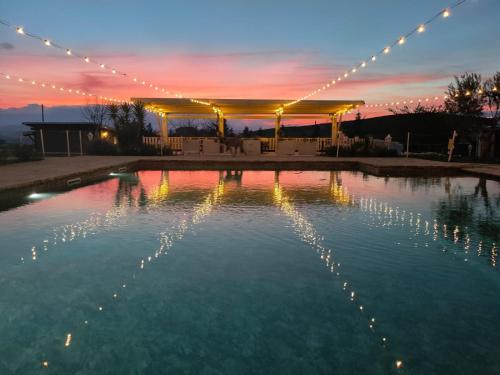 a pool of water with a tent and lights at La Collina dei Cavalieri in Belvedere Ostrense