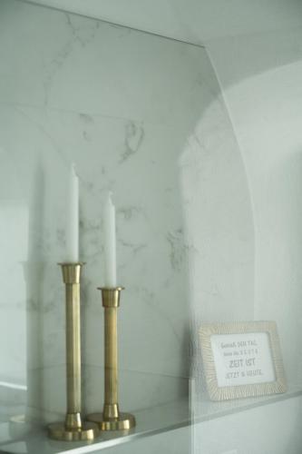 a display with two candles on a shelf with a plaque at Smarthotel Völkermarkt in Völkermarkt