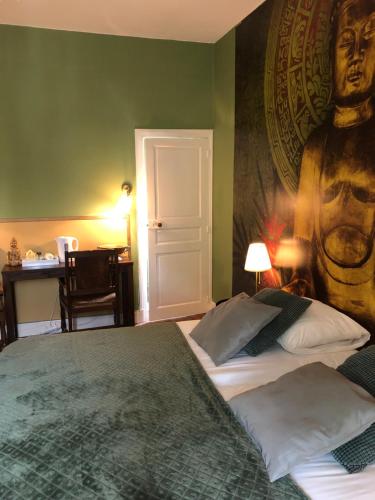 a bedroom with a large bed with a large portrait on the wall at Maison de la Comtesse in Cosne-dʼAllier