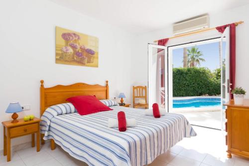 a bedroom with a bed and a view of a pool at Villa Mencia by Villa Plus in S'Algar