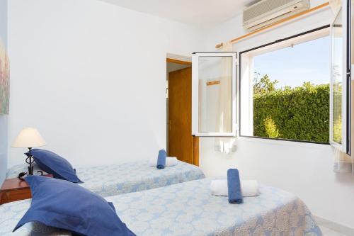 two beds in a room with a window at Villa Mencia by Villa Plus in S'Algar