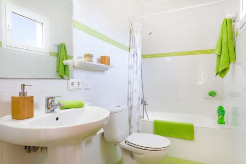a bathroom with a white toilet and a sink at Villa Mencia by Villa Plus in S'Algar