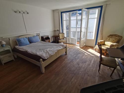 a bedroom with a bed and a chair and a window at Mignon appartement sous les toits in Guéméné-sur-Scorff