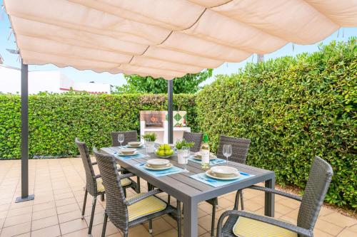 a table with chairs and an umbrella on a patio at Villa Beltran by Villa Plus in S'Algar