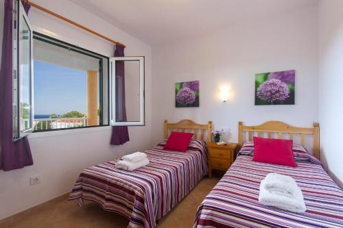 a bedroom with two beds with red pillows and a window at Villa Santo Tomas by Villa Plus in Santo Tomás