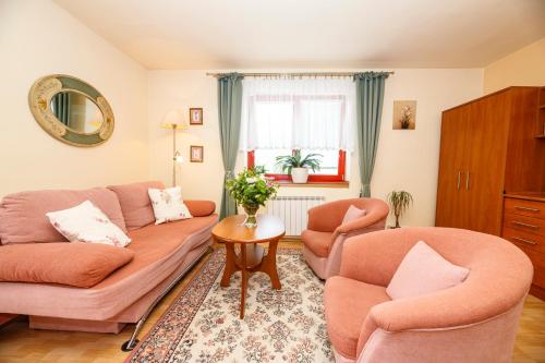 a living room with two chairs and a couch at Penzion Sinfonietta in Luhačovice