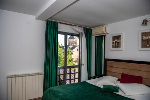 a bedroom with a bed and a large window at Hotel THR Center in Curtea de Argeş