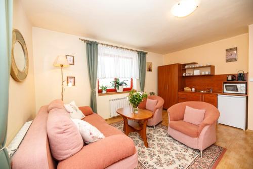 a living room with a couch and two chairs at Penzion Sinfonietta in Luhačovice