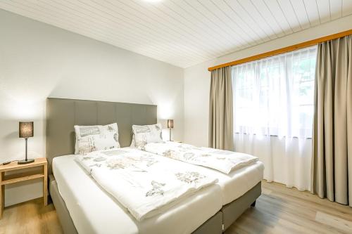 Postel nebo postele na pokoji v ubytování Lauberhorn Apartment - Aare Jungfrau AG