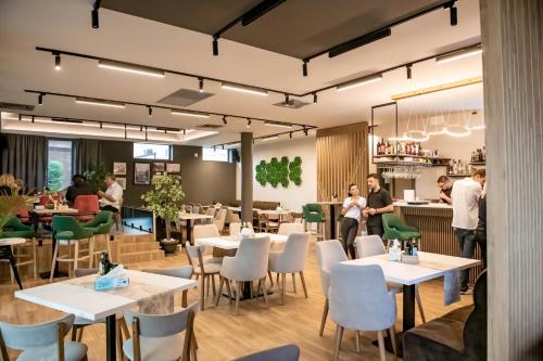 a restaurant with white tables and chairs at Hotel THR Center in Curtea de Argeş