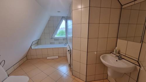 La salle de bains est pourvue d'un lavabo, de toilettes et d'une fenêtre. dans l'établissement Apartment na poddaszu, à Augustów