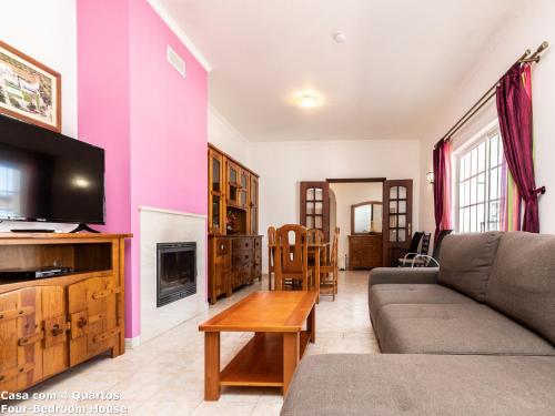 a living room with a couch and a tv at Akisol Albufeira Sun in Albufeira
