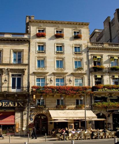 a large building with tables and chairs in front of it at Hotel des 4 Soeurs in Bordeaux