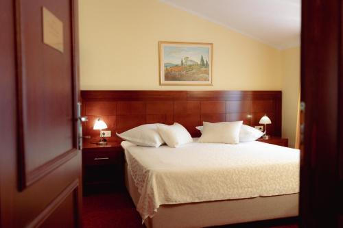 a bedroom with a large bed with white sheets and pillows at Villa Riva in Makarska