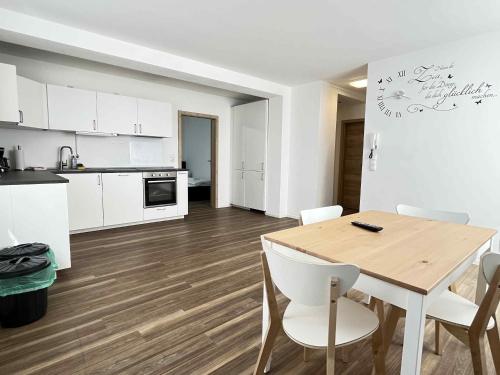une cuisine et une salle à manger avec une table et des chaises en bois dans l'établissement SAD190 - Zentrale Moderne Monteurwohnungen, à Schwandorf in Bayern