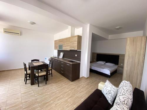 sala de estar con sofá, mesa y cama en Sunrise Apartments, Pomorie en Pomorie
