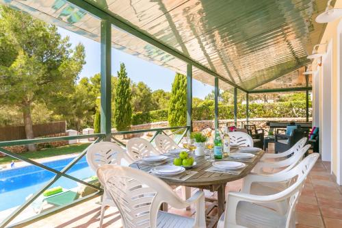 a patio with a table and chairs and a pool at Villa Serafina by Villa Plus in Son Parc