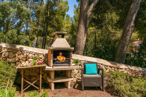a fireplace and a chair next to a stone wall at Villa Serafina by Villa Plus in Son Parc