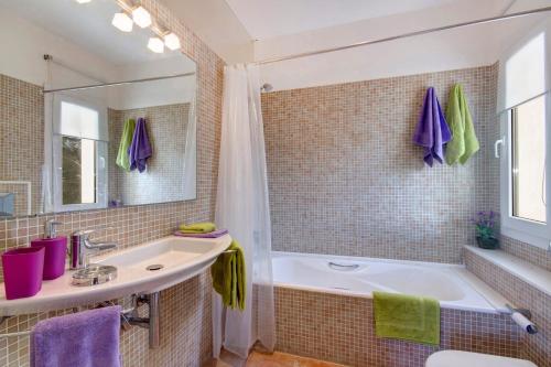 bagno con vasca, lavandino e specchio di Villa Serafina by Villa Plus a Son Parc