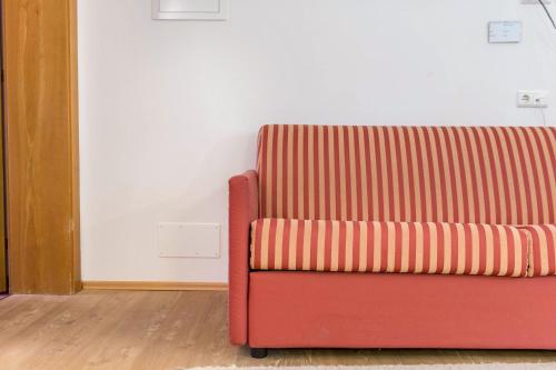 a red couch sitting in a living room at Ferienparadies Sabina Puflatsch in Alpe di Siusi