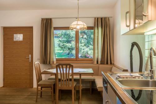 a kitchen and dining room with a table and a window at Ferienparadies Sabina Puflatsch in Alpe di Siusi