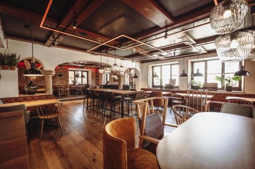 a restaurant with wooden tables and chairs and windows at Zur Mühle in Bad Birnbach