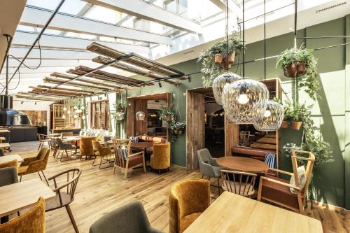a restaurant with tables and chairs and plants at Zur Mühle in Bad Birnbach
