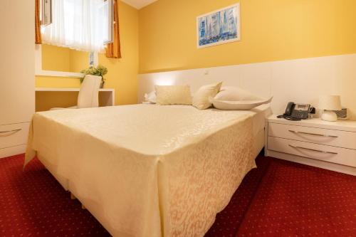 a bedroom with a large bed with yellow walls at Villa Riva in Makarska