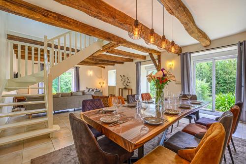 une salle à manger avec une longue table et des chaises dans l'établissement KER CASE A NOU - Belle Longère familiale à la campagne à 10 minutes de Vannes, à Monterblanc