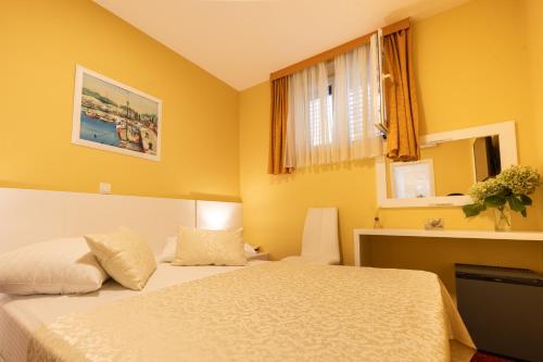 a bedroom with a white bed and a window at Villa Riva in Makarska