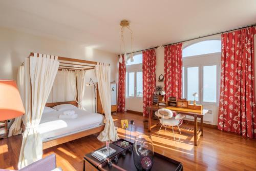 sypialnia z łóżkiem, biurkiem i stołem w obiekcie L'Ambassadeur - Magnifique appartement dans l'ancien hôtel Ar Vro w mieście Saint-Cast-le-Guildo