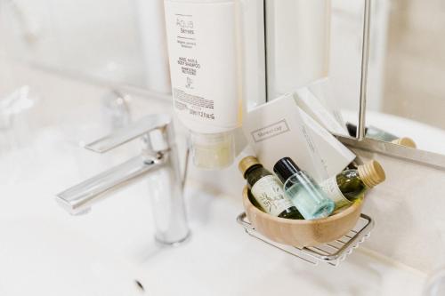 a bathroom sink with a basket with bottles of alcohol at Villa Riva in Makarska