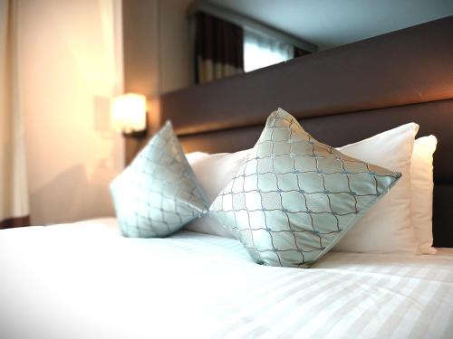 two pillows sitting on top of a bed at Atrium Hotel Heathrow in Hillingdon